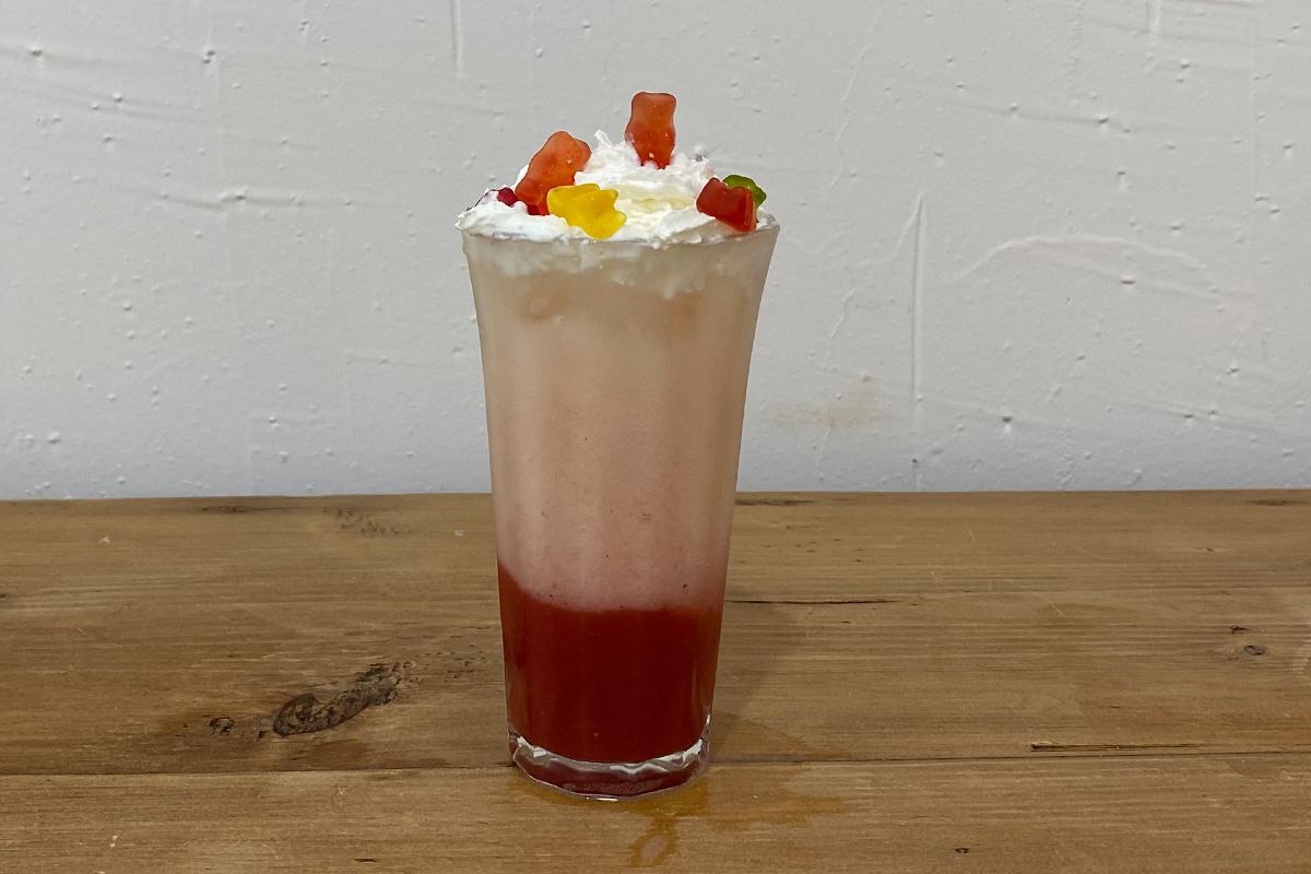 Makgeolli cocktail with strawberry juice with whipped cream and gummies on top