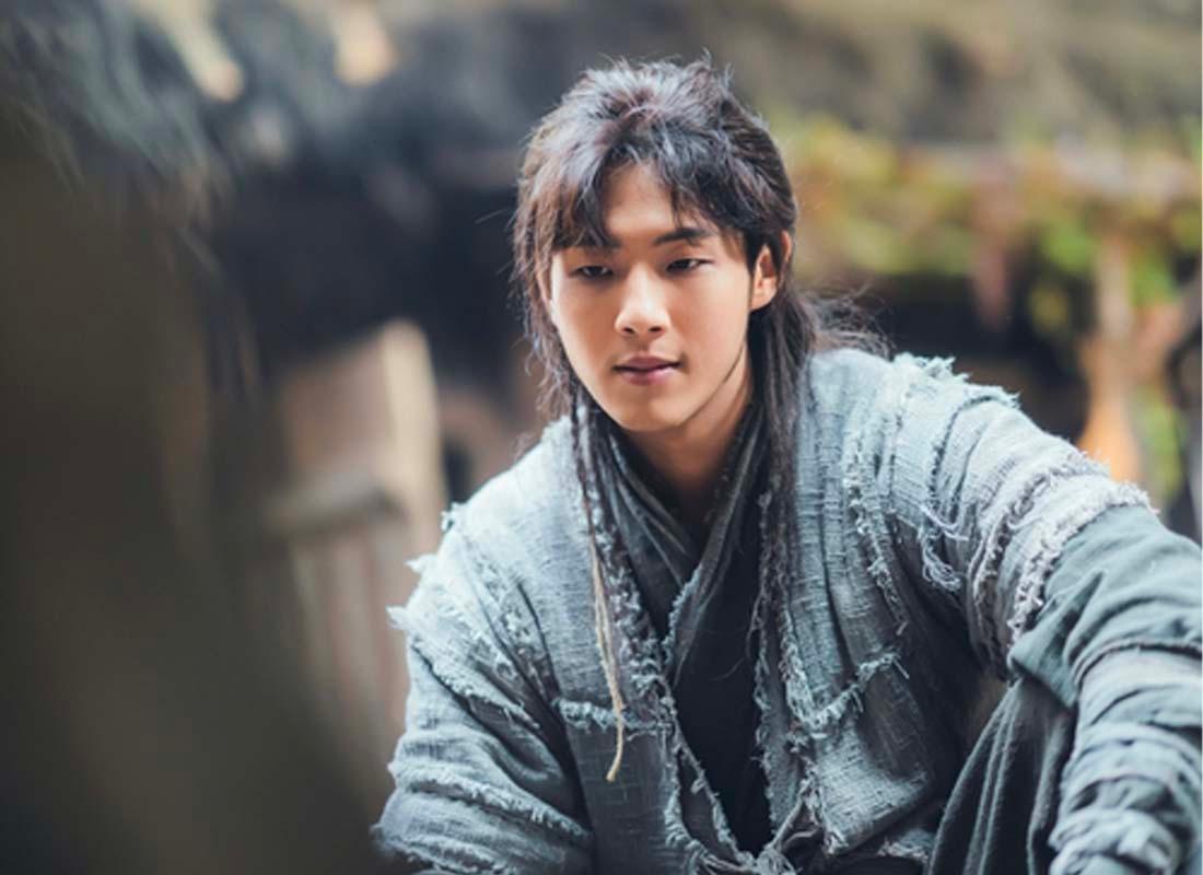 ภาพนักแสดงเกาหลีชายในชุดโจรสวมกางเกงขาด นั่งอยู่ในฉากภาพยนตร์