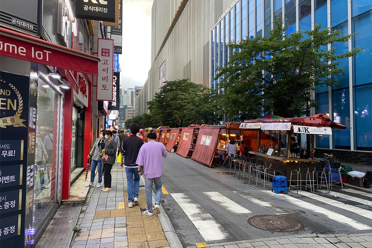 Busan Korea Seomyeon Pojangmacha Street, city buildings, daytime, people walking and drinking at bars