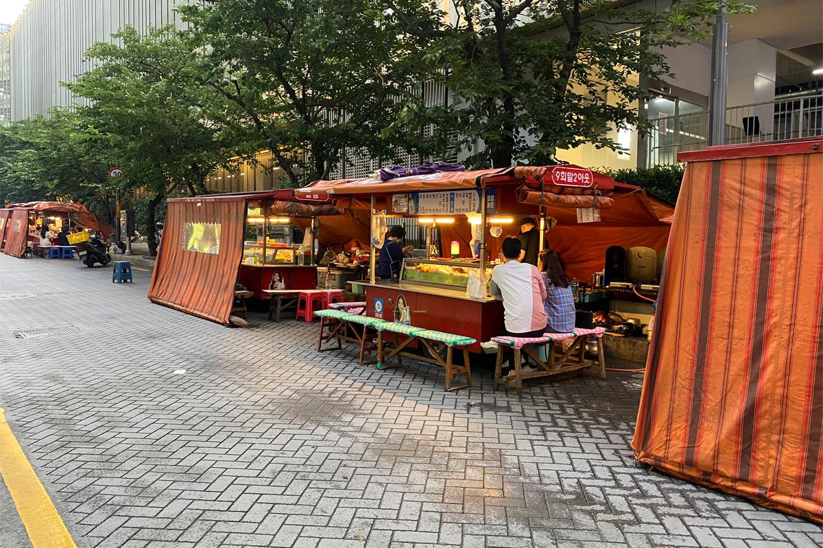 Busan Korea Seomyeon Pojangmacha Street, people drinking and eating at stall bars, daytime