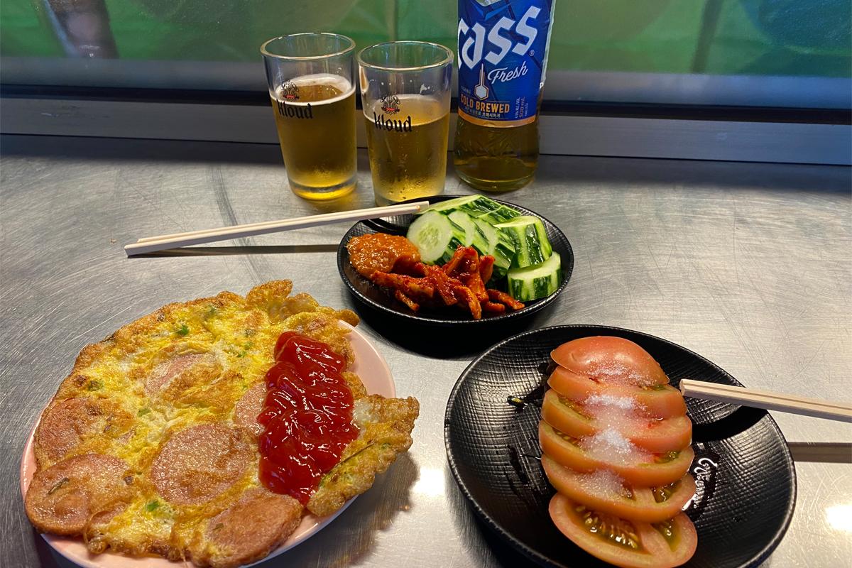Busan Korea Seomyeon Pojangmacha Street, drinking beer, ham omelet, cucumber, dried radish, and tomato salad appetizers