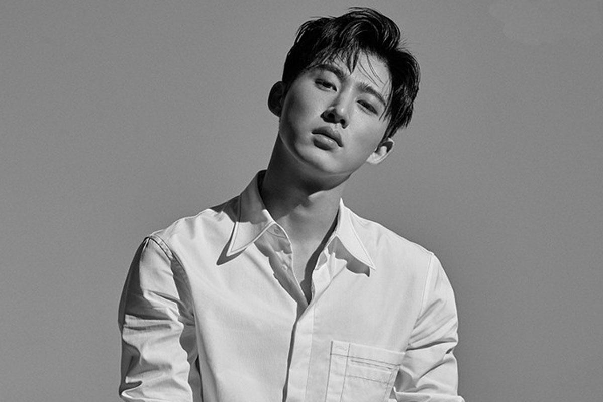 ภาพข่าวขาวดำของไอดอลเกาหลีในเสื้อเชิ้ตสีขาว จากคดีความของ B.I. โดยไม่มีการกล่าวถึงใบหน้า