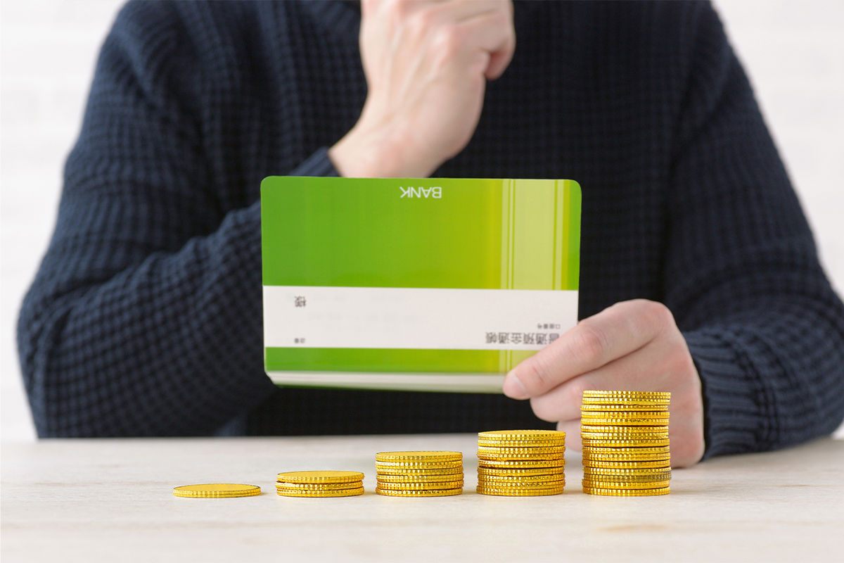 man contemplating looking at bank account with coins on the desk