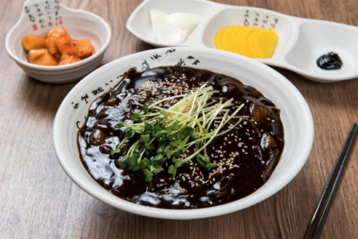 韓國炸醬麵擺盤精美，上面撒有芝麻和綠色嫩芽，四月十四號黑色情人節單身者的風味菜餚。