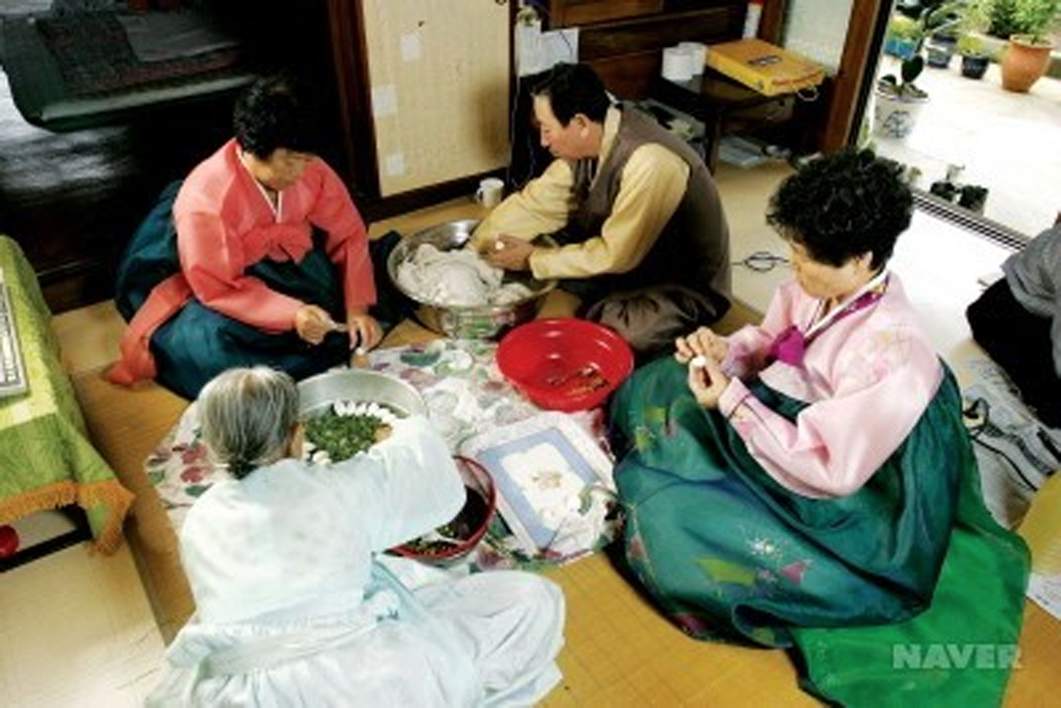 在韓國的家庭中，成員們圍坐一起製作松餅，這是中秋節的傳統習俗，象徵團聚和豐饒。