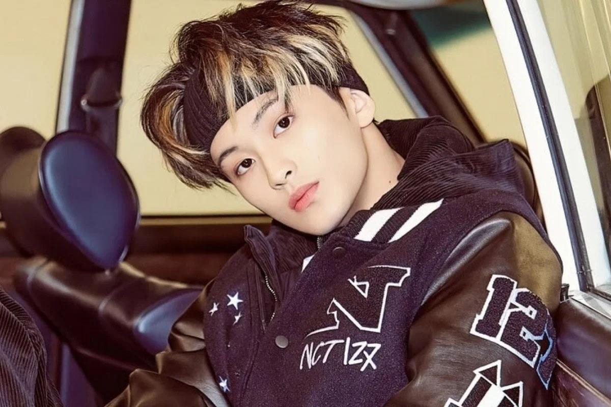 มาร์คจาก NCT อยู่ในรถสปอร์ตพร้อมแจ็กเก็ตหนังที่มีโลโก้ NCT 127