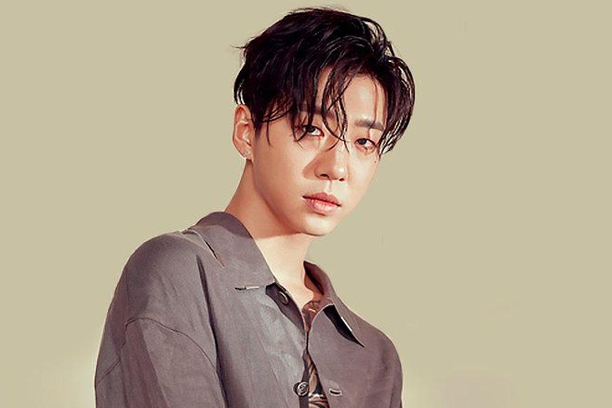 ยงกุกในเสื้อลำลองสีเทาอมน้ำตาลอ่อนกับพื้นหลังเรียบง่าย