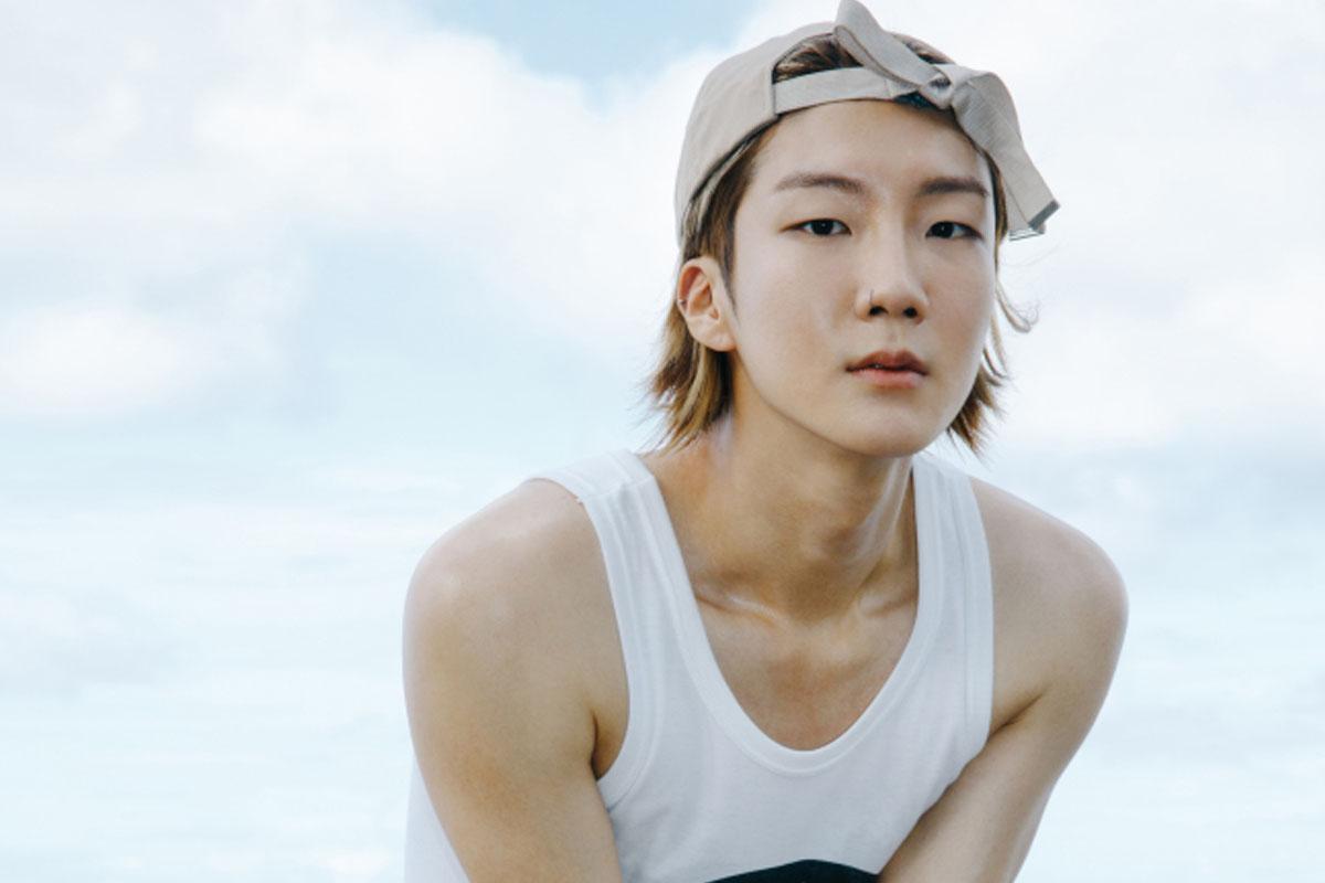 ซึงฮุนจาก WINNER สวมเสื้อกล้ามสีขาวและหมวกสีเบจที่ชายหาด