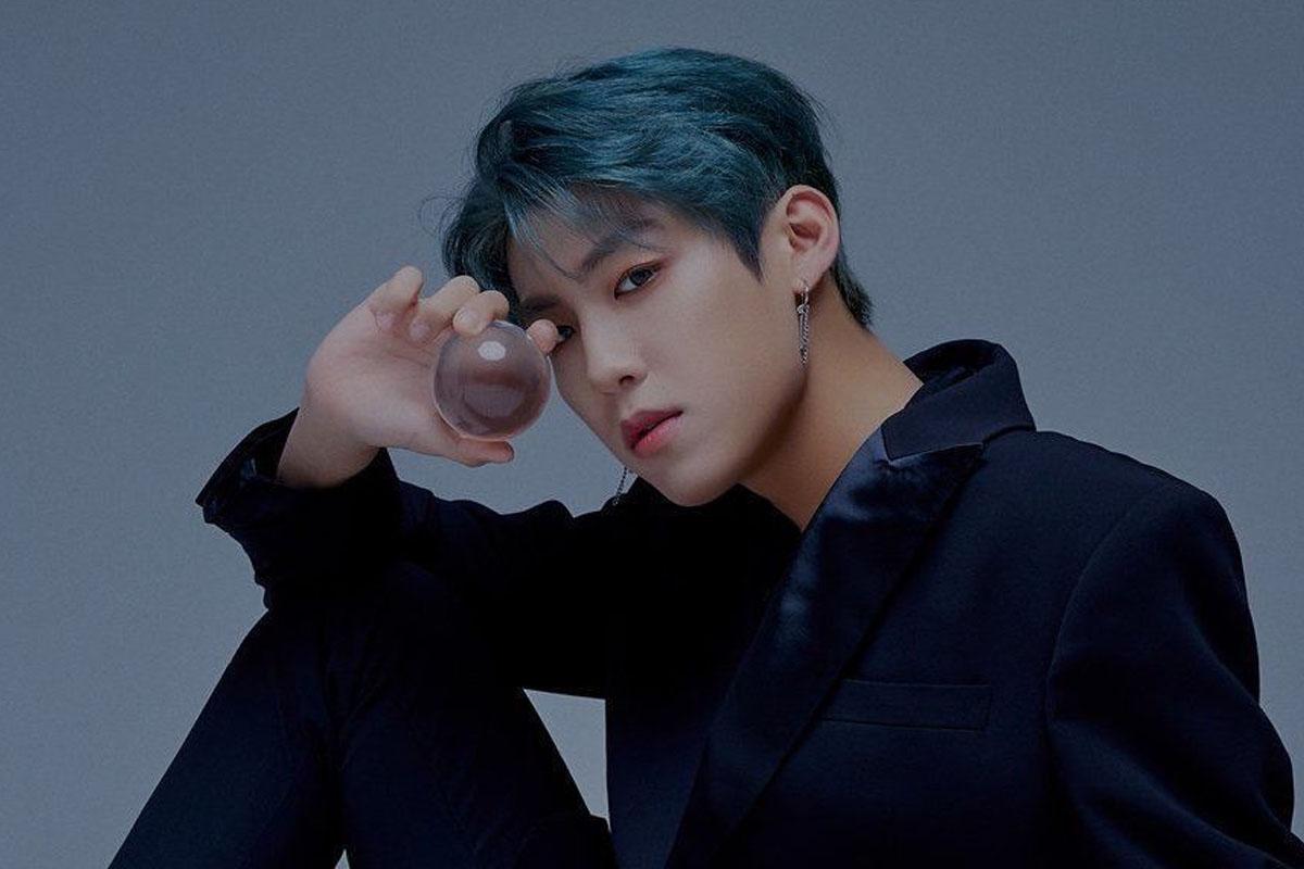 อูจินจาก AB6IX ในเสื้อคลุมสีน้ำเงินพร้อมสร้อยคอหลายเส้น