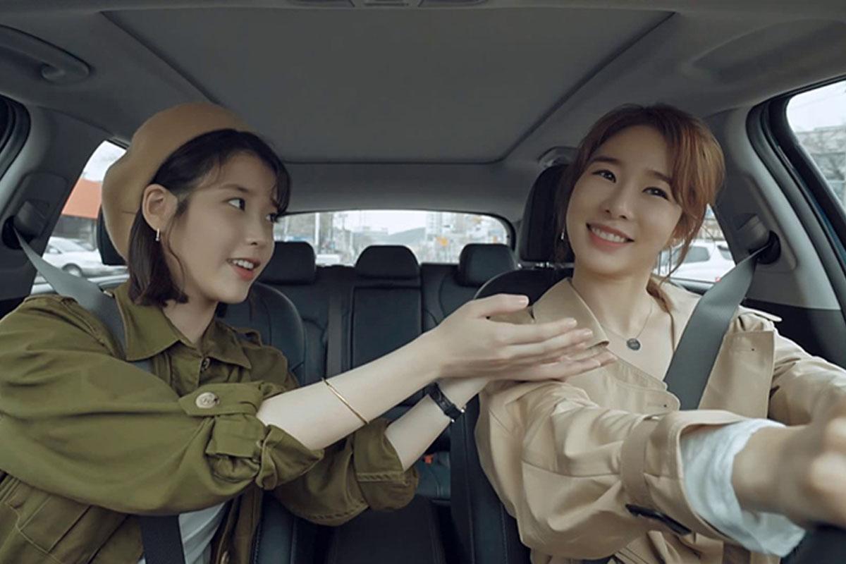 ผู้หญิงสองคนในรถยนต์กำลังพูดคุยและขับรถ