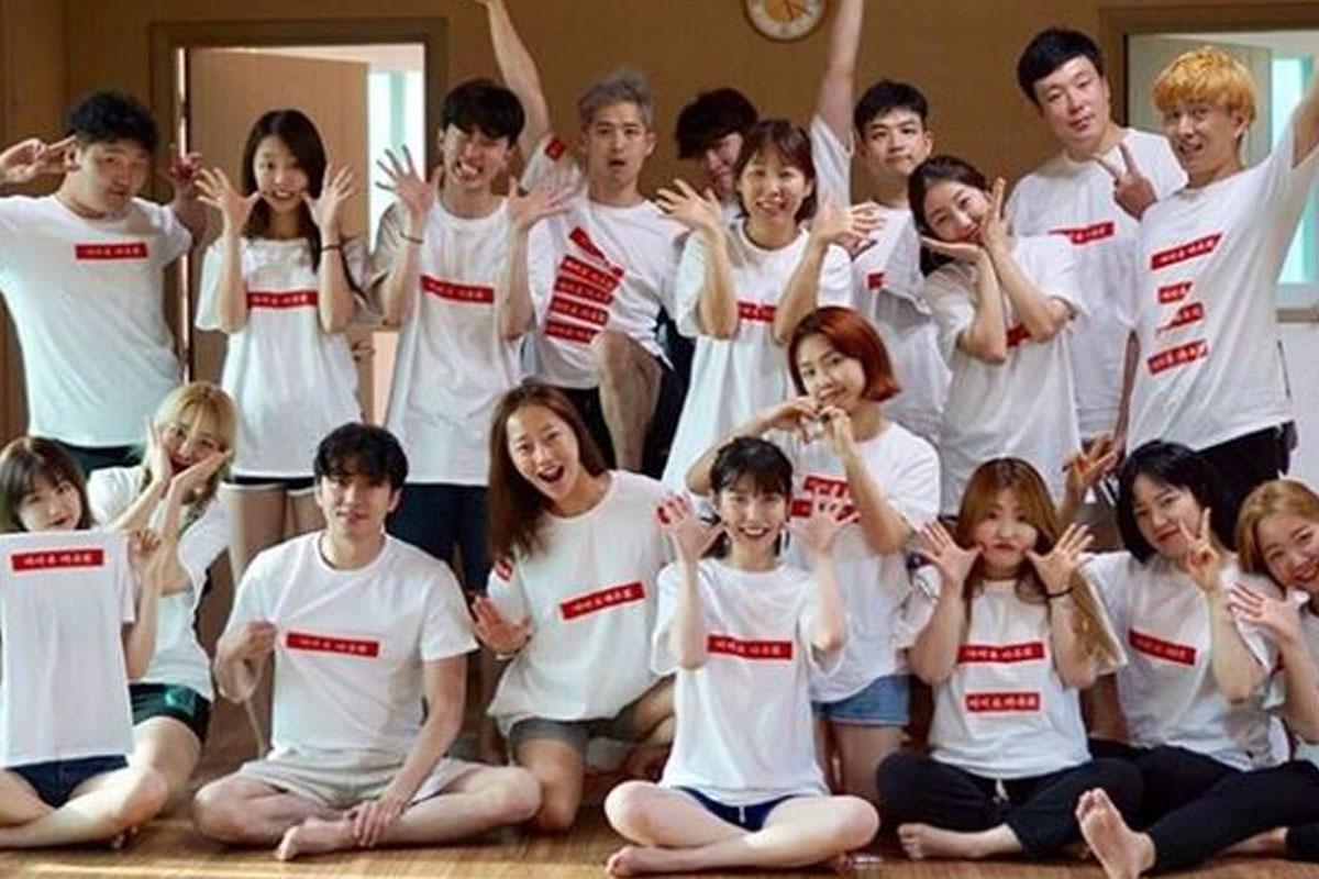 กลุ่มคนสวมเสื้อยืดสีขาวพร้อมข้อความสีแดงยืนในห้อง