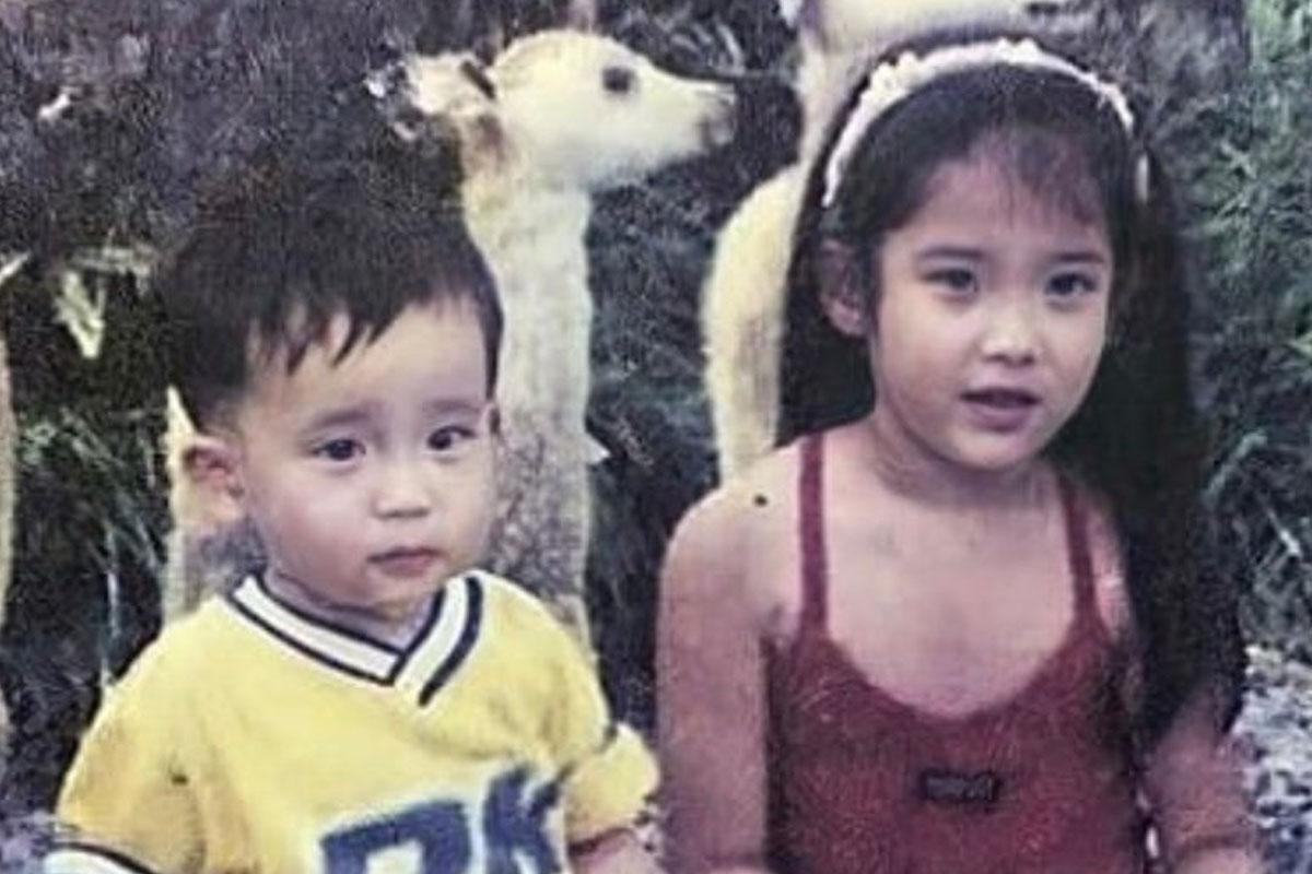 ภาพถ่ายเก่าของเด็กชายสวมเสื้อสีเหลืองและเด็กหญิงในเสื้อสายเดี่ยวสีแดงที่สวนสัตว์