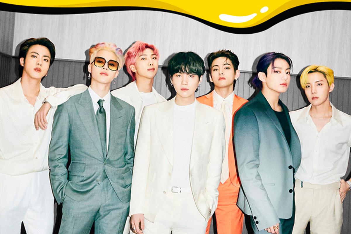 韓國男團BTS在一次活動中的團體合影，他們穿着各色西裝，展現出時尚風格。