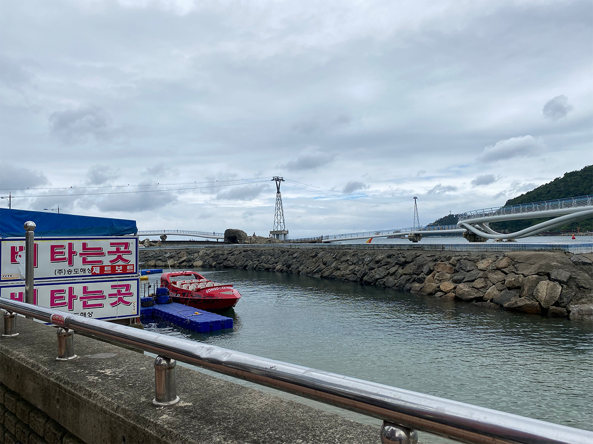 A view of Songdo Beach with a red boat on water