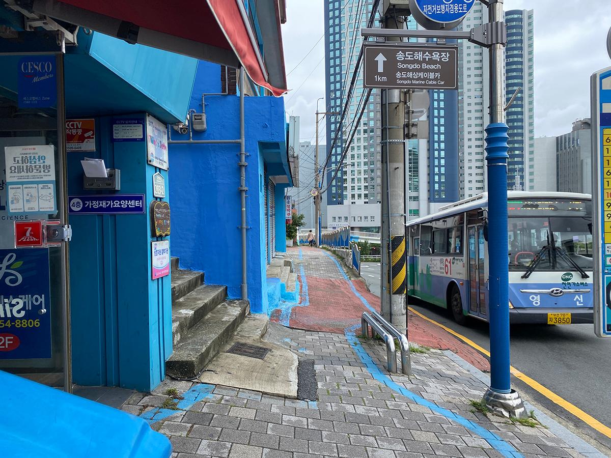 Exterior view of a bright blue building housing the 7th Street Pizza in Busan, South Korea.