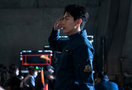 撮影セットで敬礼している俳優のシーン