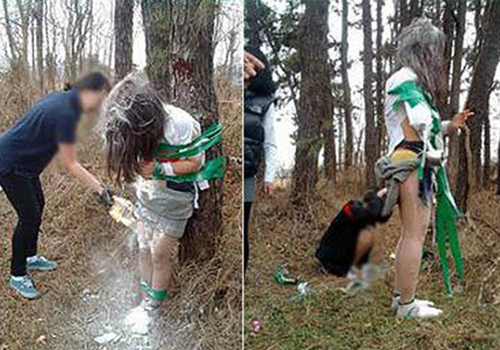 Student with torn uniform tied to tree being covered in flour by another student