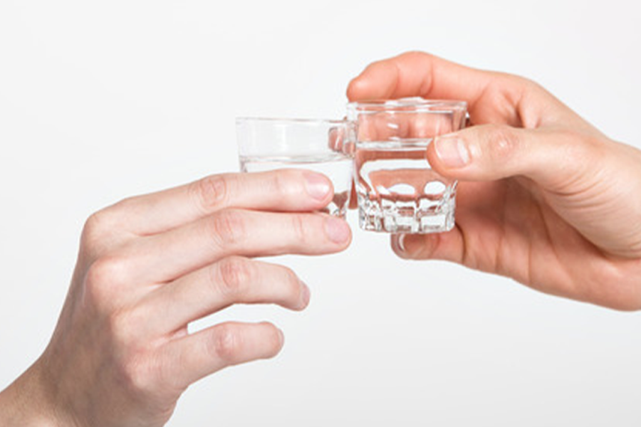 两个人在进行直饮，使用的是小型清酒杯，展示了烧酒文化中常见的干杯场景。