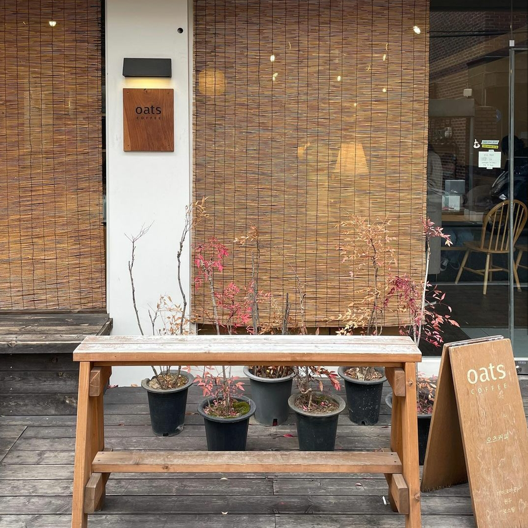 ソウル、竜山に位置するオーツコーヒーの外観。秋の季節感を感じさせる植木が並ぶウッドデッキ。ペットと一緒に訪れるのに最適なカフェで知られています。