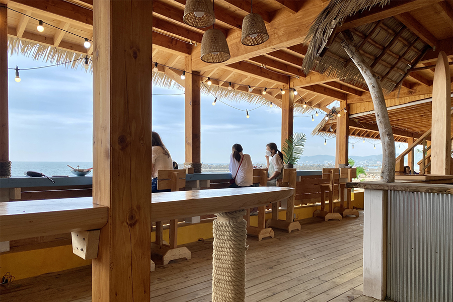 用餐區設有木製桌椅，放置在海景前面，提供愜意的用餐體驗。