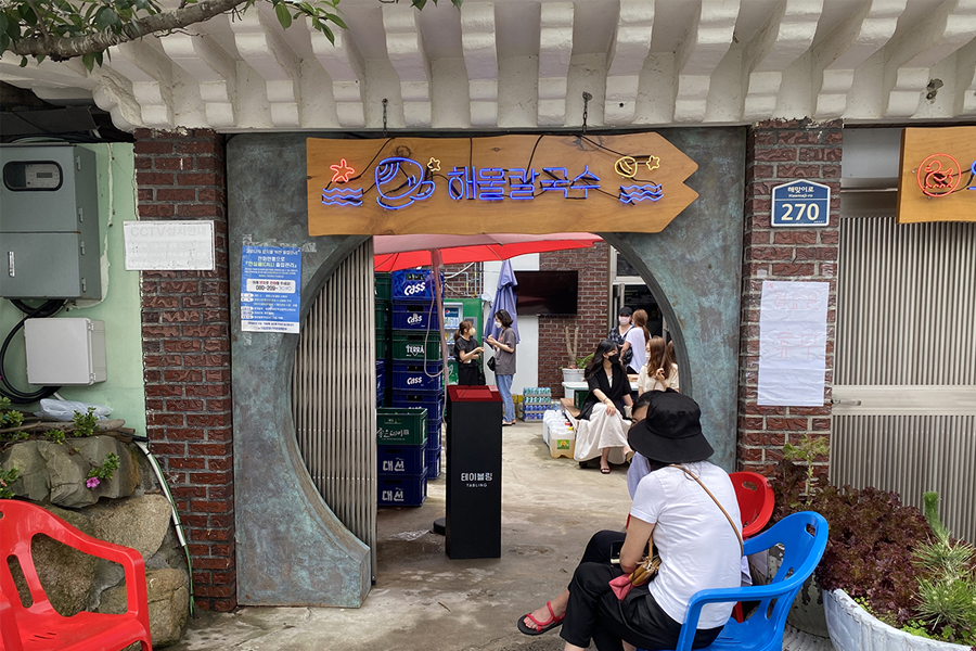 釜山機張海鮮刀削麵店的入口，展示餐廳的獨特設計和吸引人的氛圍。