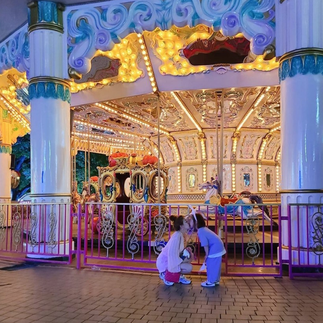 Kid and mom in front of carousel