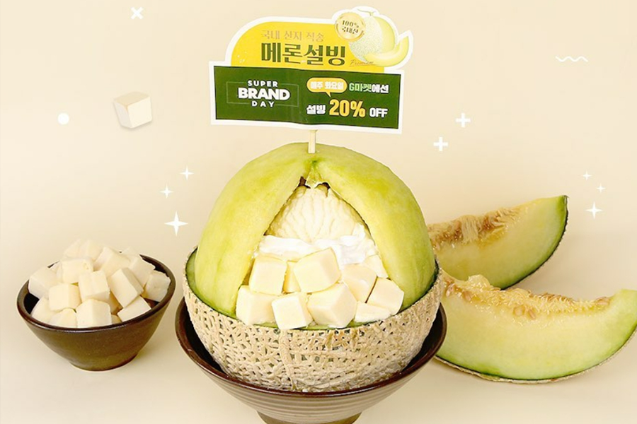 韩国雪冰甜品店提供的优格哈密瓜雪冰，放在切开的哈密瓜中，旁边附有切块哈密瓜和奶油奶酪，清新爽口。