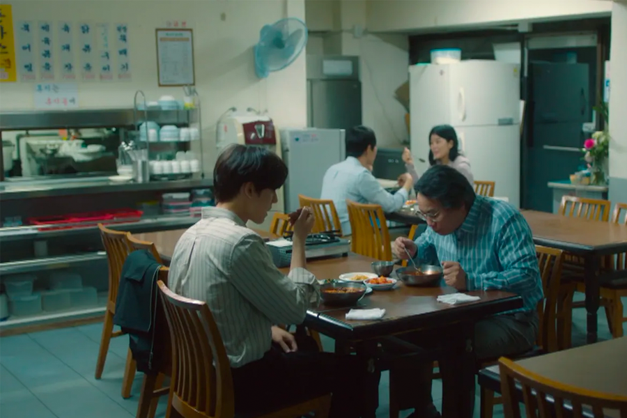 在韓國司機食堂的內部一側，餐桌上擺滿韓國傳統料理，展示出食堂的日常氛圍