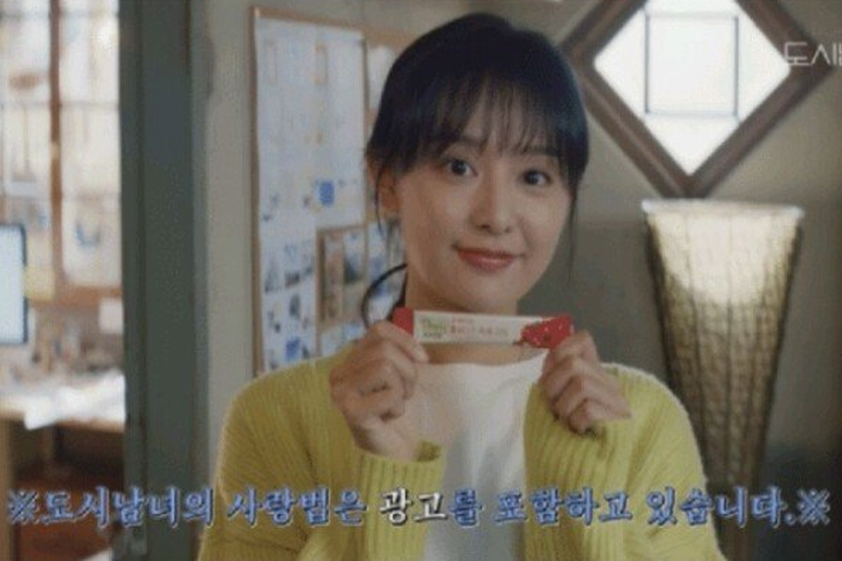 一個人手持一條巧克力棒，底部字幕顯示該劇包含廣告內容。