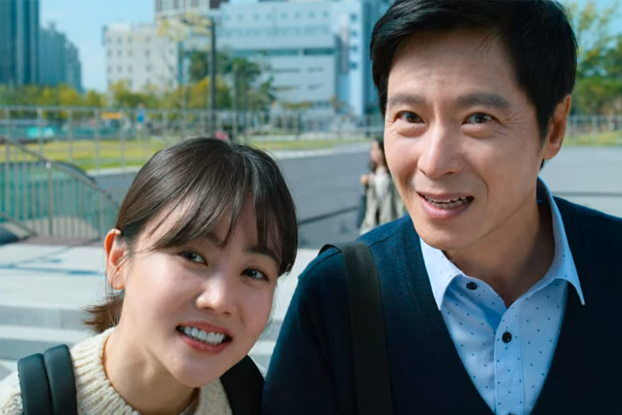 两人在户外站着，背景为现代城市景观。