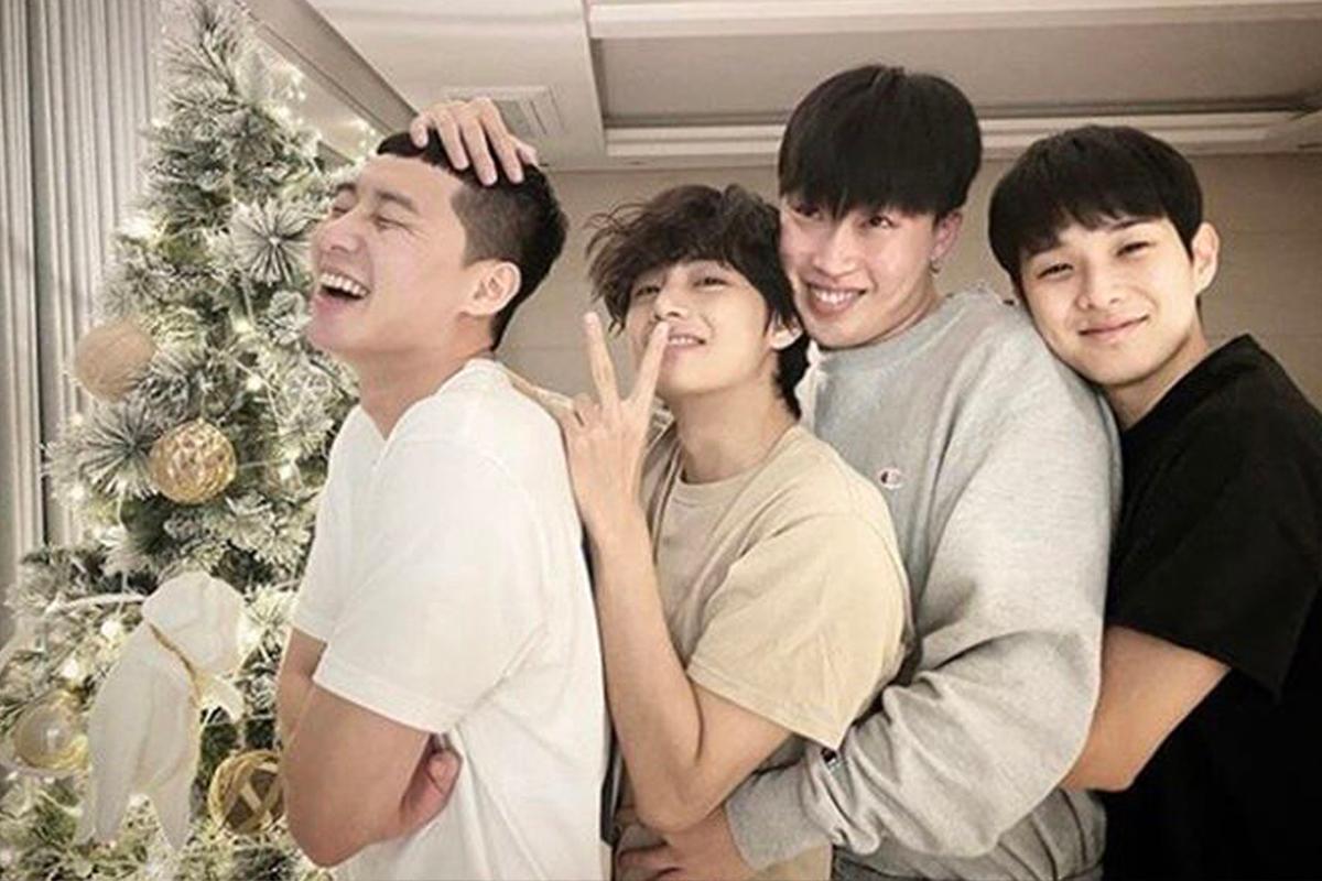 綠色聖誕樹旁,韓星好友排成一列,姿勢親密,非常有節日氛圍。