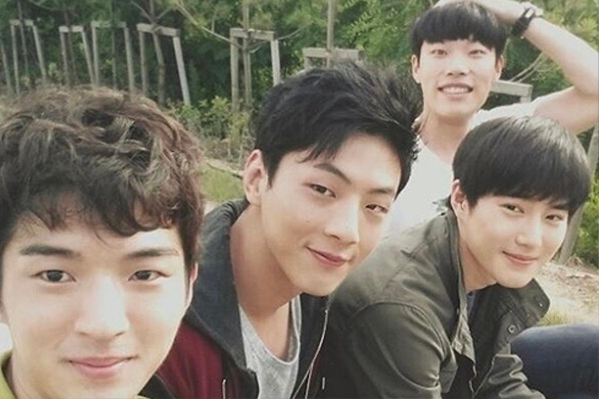 韓星在户外樹林背景下歡聚一堂,表情輕鬆愉快,展現休閒自如的時刻。