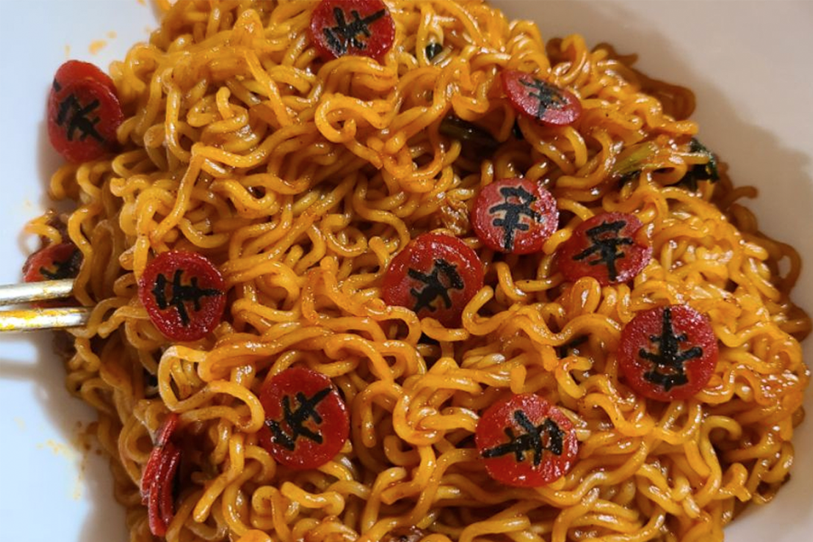 攤在桌面的辛拉麵炒麵和不同配料的近距離圖像，顯示其豐富多元的韓國料理風味。