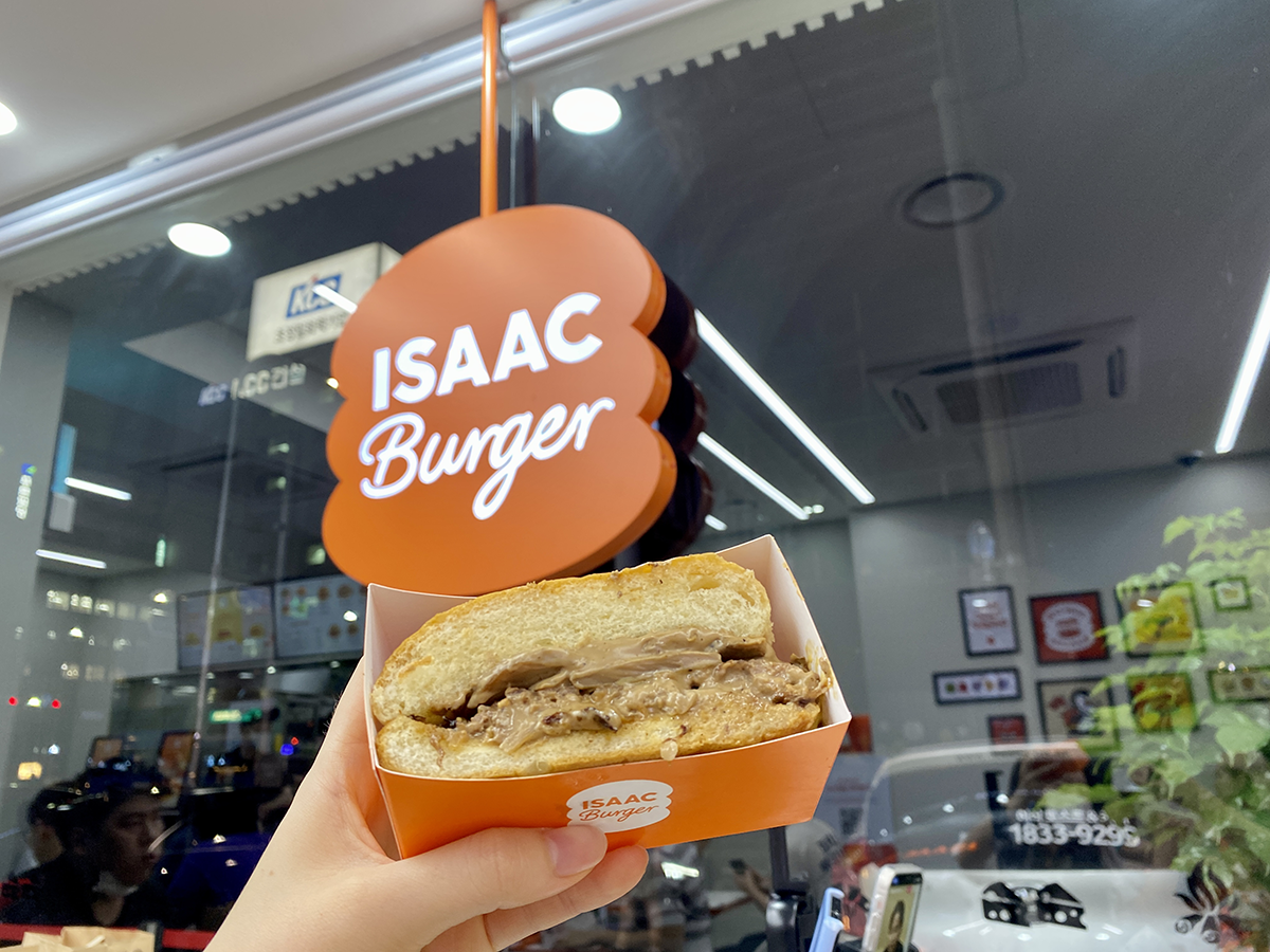 ISAACバーガーの看板の前で撮影されたマッシュルームビーフバーガー