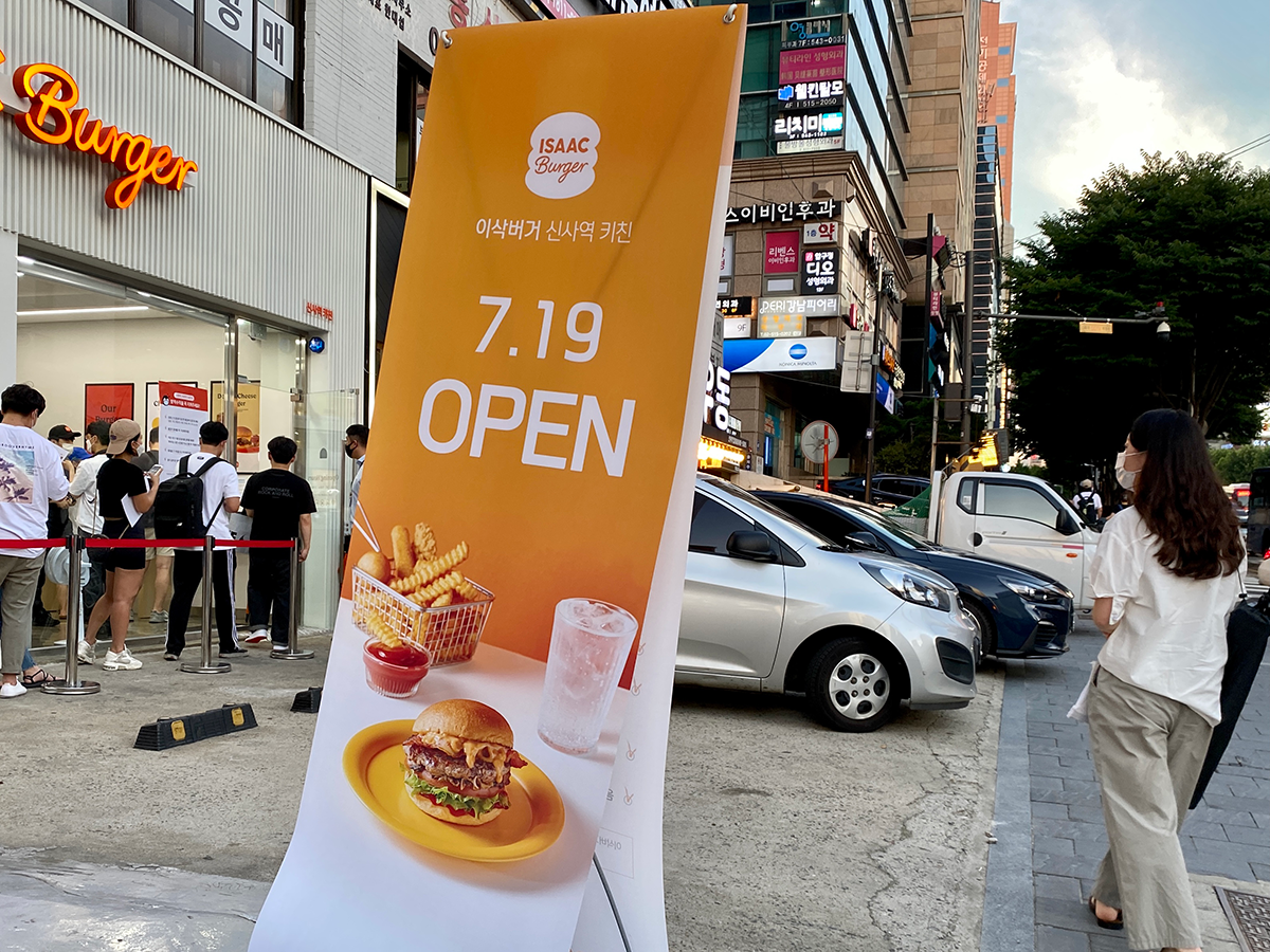 新沙駅近くのISAACバーガーのオープンを告知する店舗前の看板