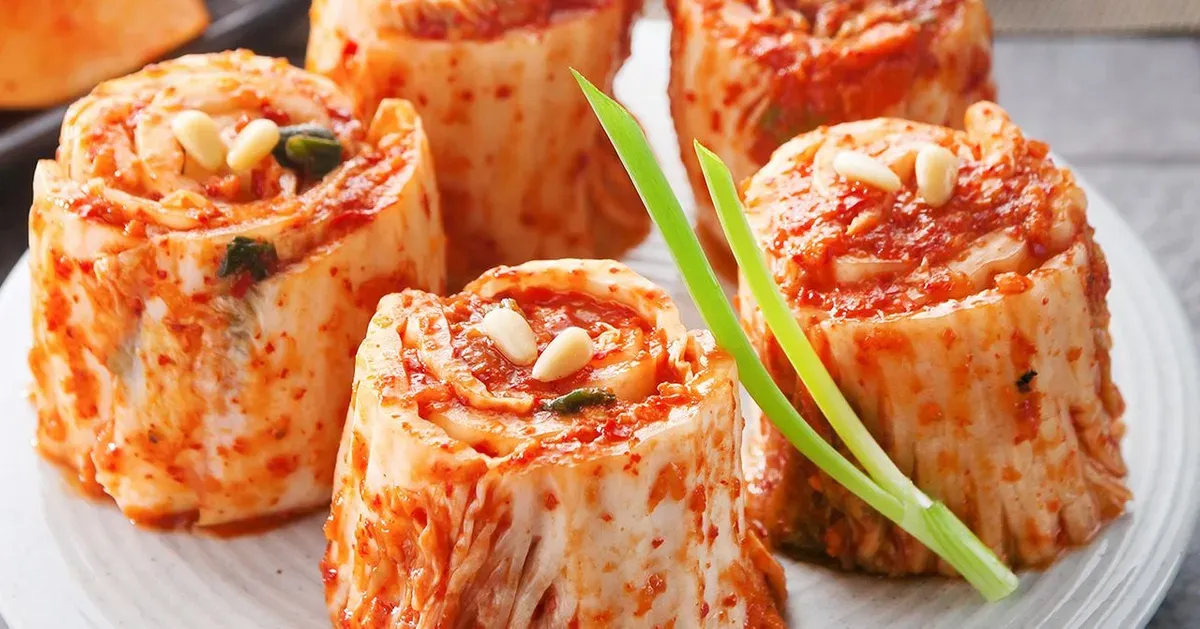 圓形捲心白菜包裹的韓式泡菜（辛奇），搭配新鮮蔥綠，突出泡菜的豐富層次。