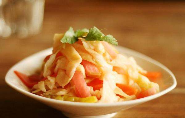 新鮮切片的四川泡菜（Paocai），以白色陶瓷盤呈現，展示中國泡菜的特有風格。