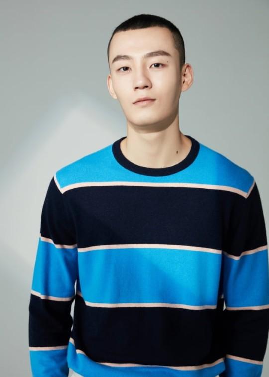 青と黒のボーダー柄のセーターを着た人物、ポーズをとって背景がぼやけている写真。キム·ミングィの写真となっているが、顔はぼやけている。毎日経済の著作権がある写真。