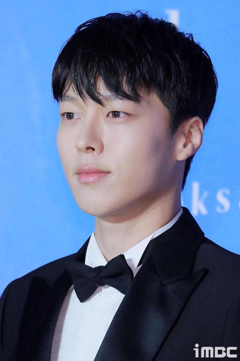 韓国俳優チャン・ギヨンがタキシードと蝶ネクタイを身に着けて、公式イベントに出席している姿。