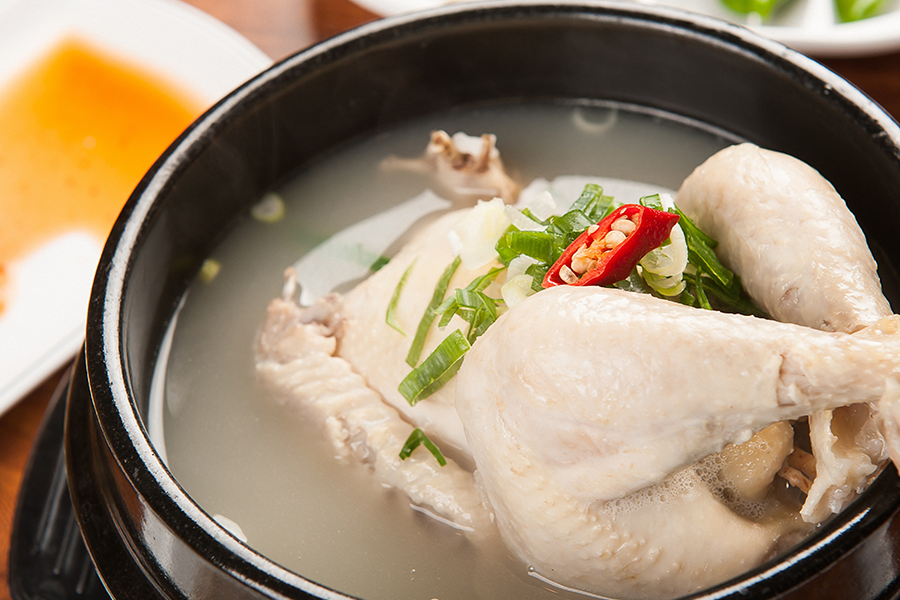 精美韩国传统补身料理，参鸡汤特写，清爽的鸡肉和营养丰富的汤汁完美结合。