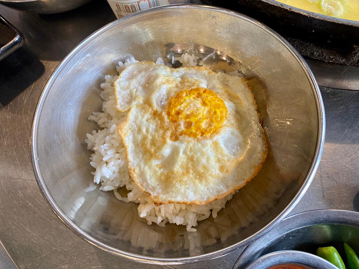 rice with egg on top in a silver bowl