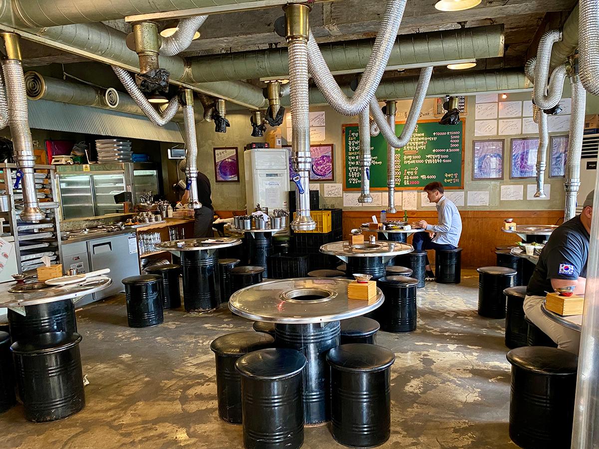 Steel tables and black round chairs at a Korean barbecue restaurant in Busan