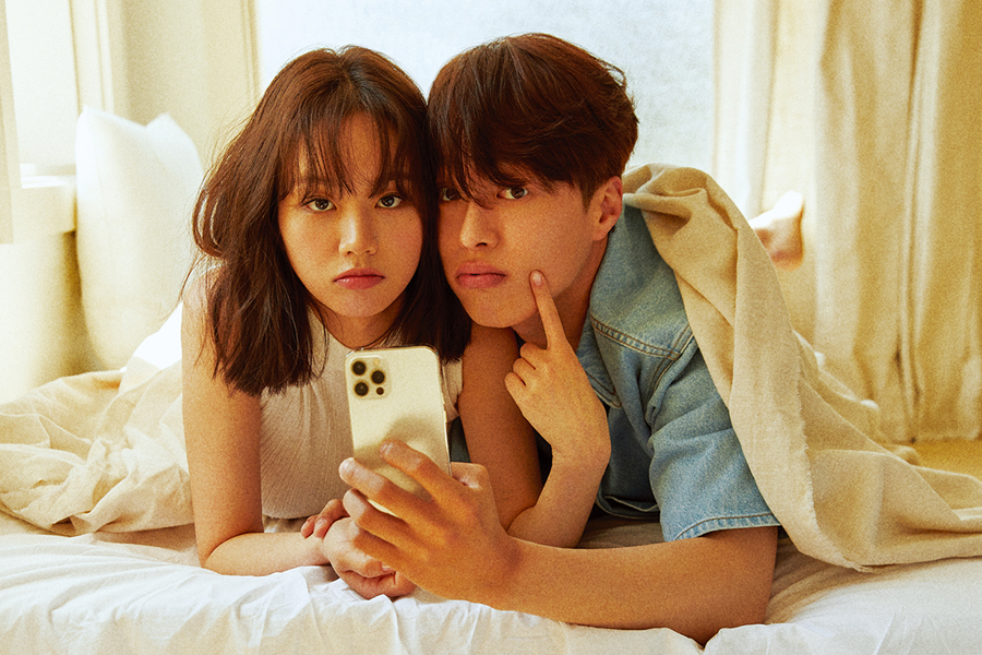 情侣在同一个房间里使用手机，反映出现代韩国年轻人同居生活的个人空间与紧密关系。