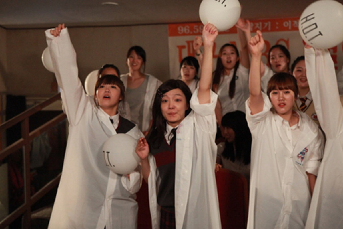 แฟนคลับของ H.O.T ยืนเรียงรายในคอนเสิร์ตแสงไฟสีม่วง พวกเขากําลังทํารูปแบบแฟนชานท์ พะยอมสโลแกนด้วยความรัก