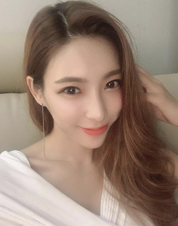 長い髪で白い服を着た女性、現在は顔がぼかされているが、ニュース記事に関連している写真