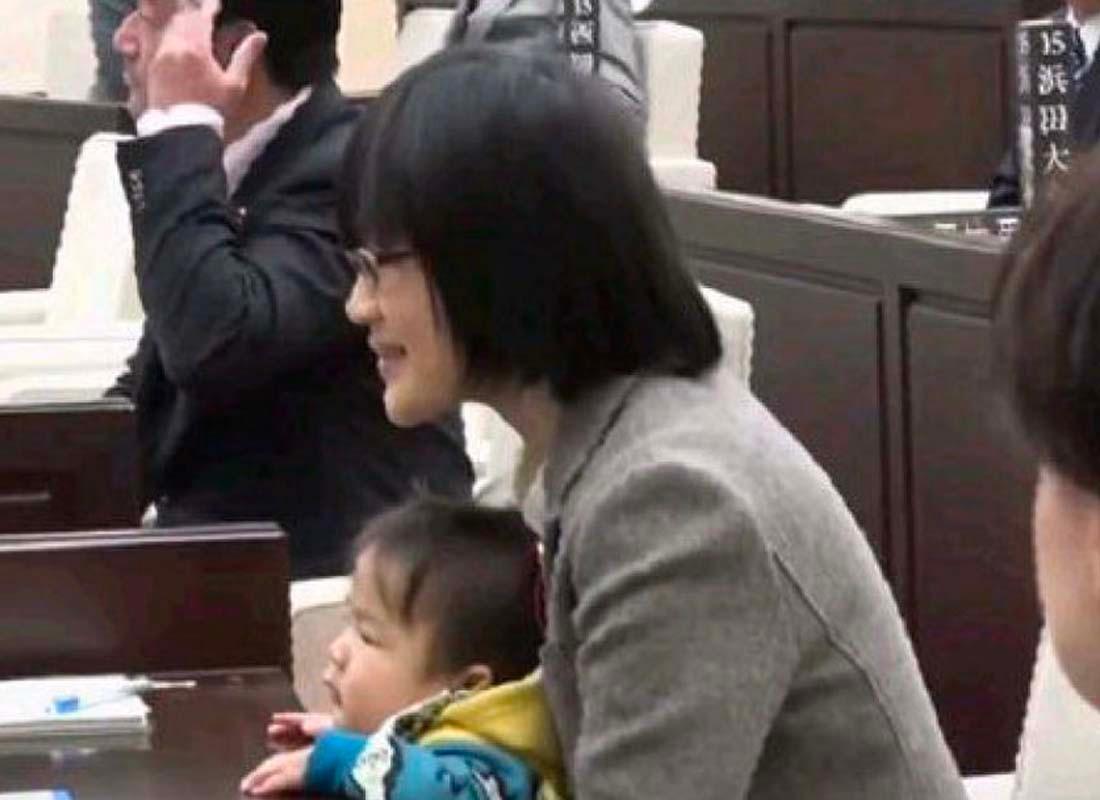 ผู้หญิงเข้าร่วมการประชุมในเกาหลีพร้อมกับลูกซึ่งนั่งที่โต๊ะข้างๆ ภาพสะท้อนถึงความสมดุลระหว่างการทำงานและการดูแลบุตรชายในสภาพแวดล้อมการเมือง