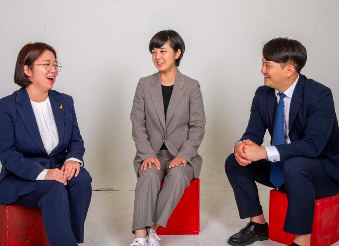 สามนักการเมืองเกาหลีที่นั่งประชุมด้วยกัน สวมชุดสูท โดยเป็นภาพสะท้อนการเติบโตของนักการเมืองรุ่นใหม่ในเกาหลีที่มีส่วนร่วมในบทสนทนาเกี่ยวกับสิทธิและนโยบายทางสังคม