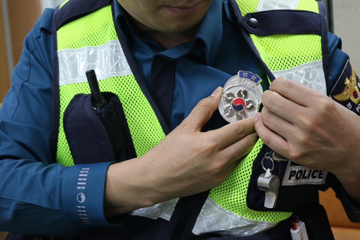 Korean police officer adjusting badge