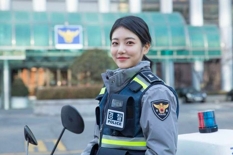 韩国警察在警局内与同事讨论工作，展示了内部工作的协调和沟通。