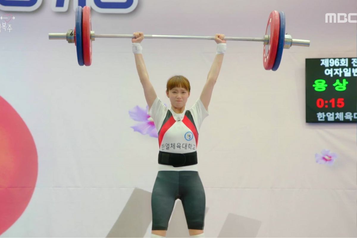 Một vận động viên cử tạ nữ đang nâng tạ trên đầu trong một cuộc thi cử tạ tại Hàn Quốc.